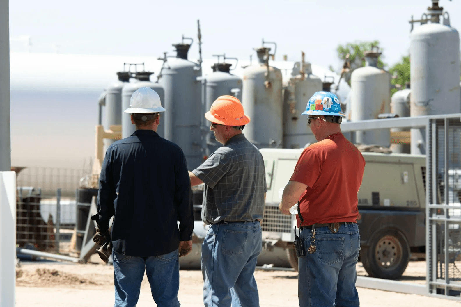 Engineers in hard hats inspecting equipment on site